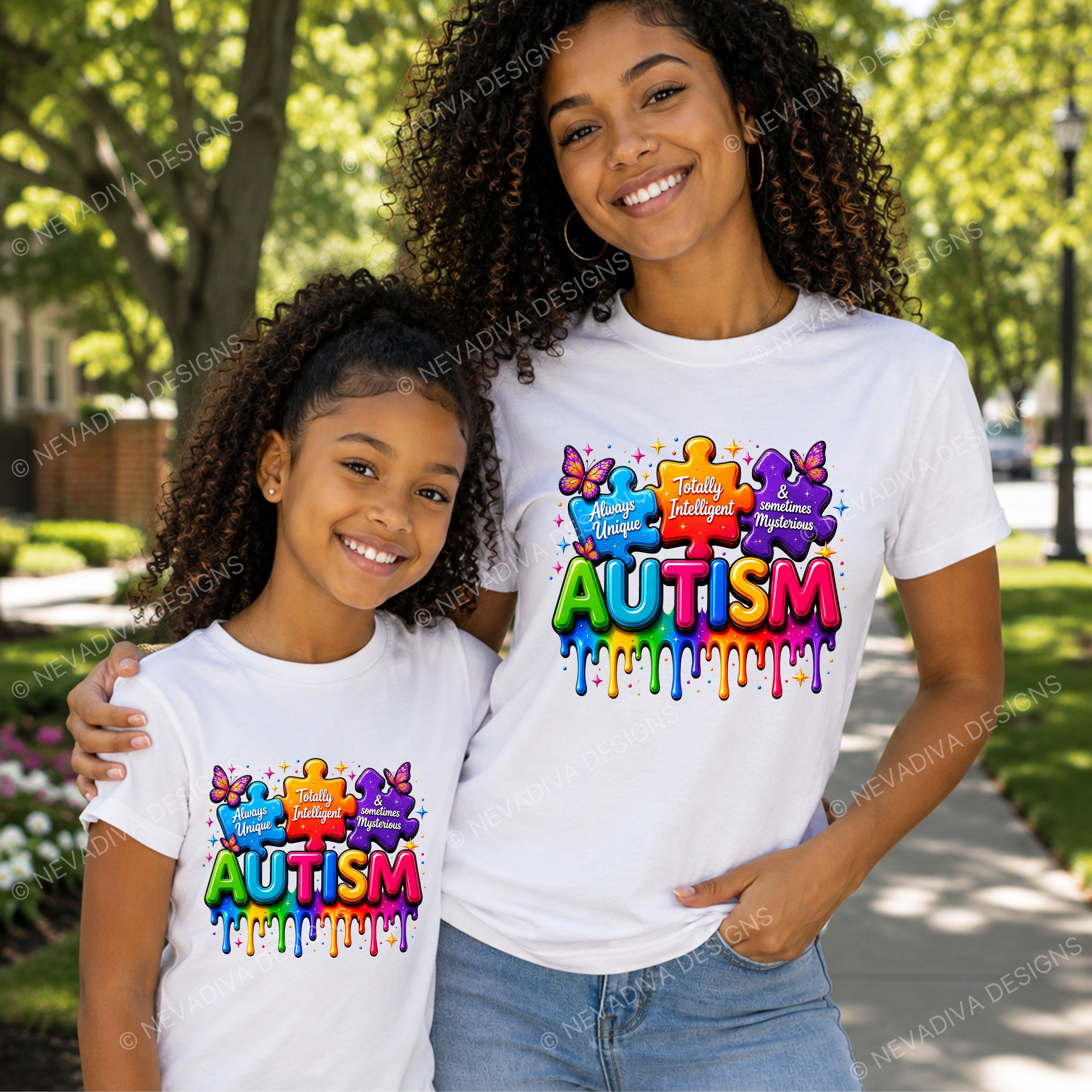 A woman and a young girl wearing matching white t-shirts with a colorful 'Autism' puzzle graphic on the front, standing outdoors on a sunny sidewalk with trees in the background.