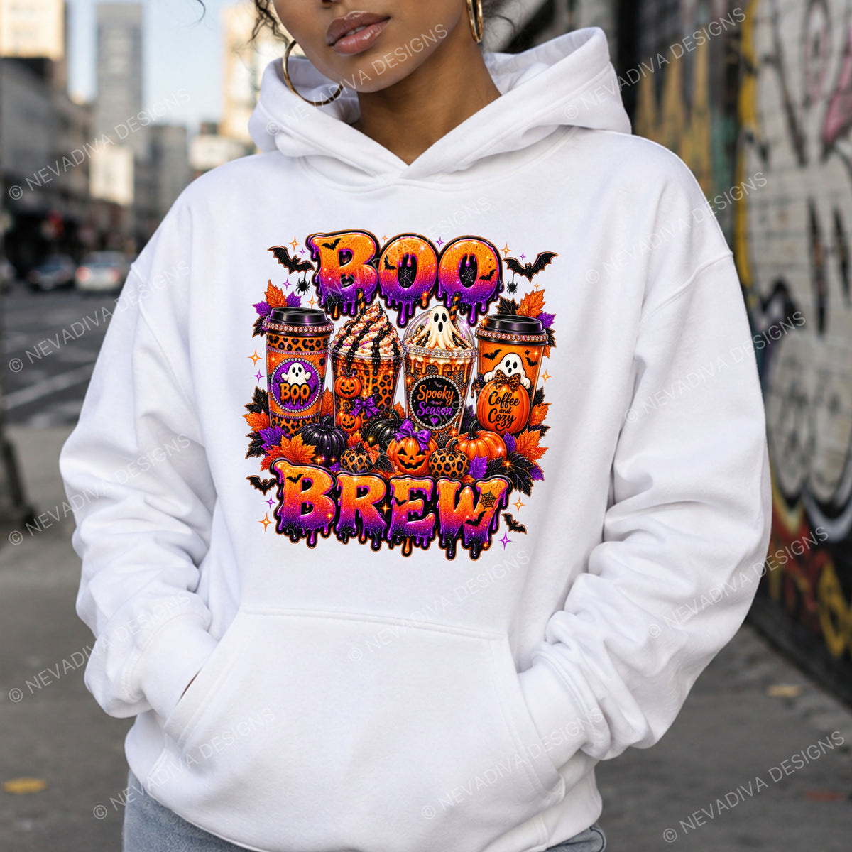 A person wearing a white pullover hoodie with a colorful Halloween-themed graphic print on the front that reads 'BOO BROW' with pumpkins, ghosts, bats, and orange leaves, photographed outdoors on a city street.