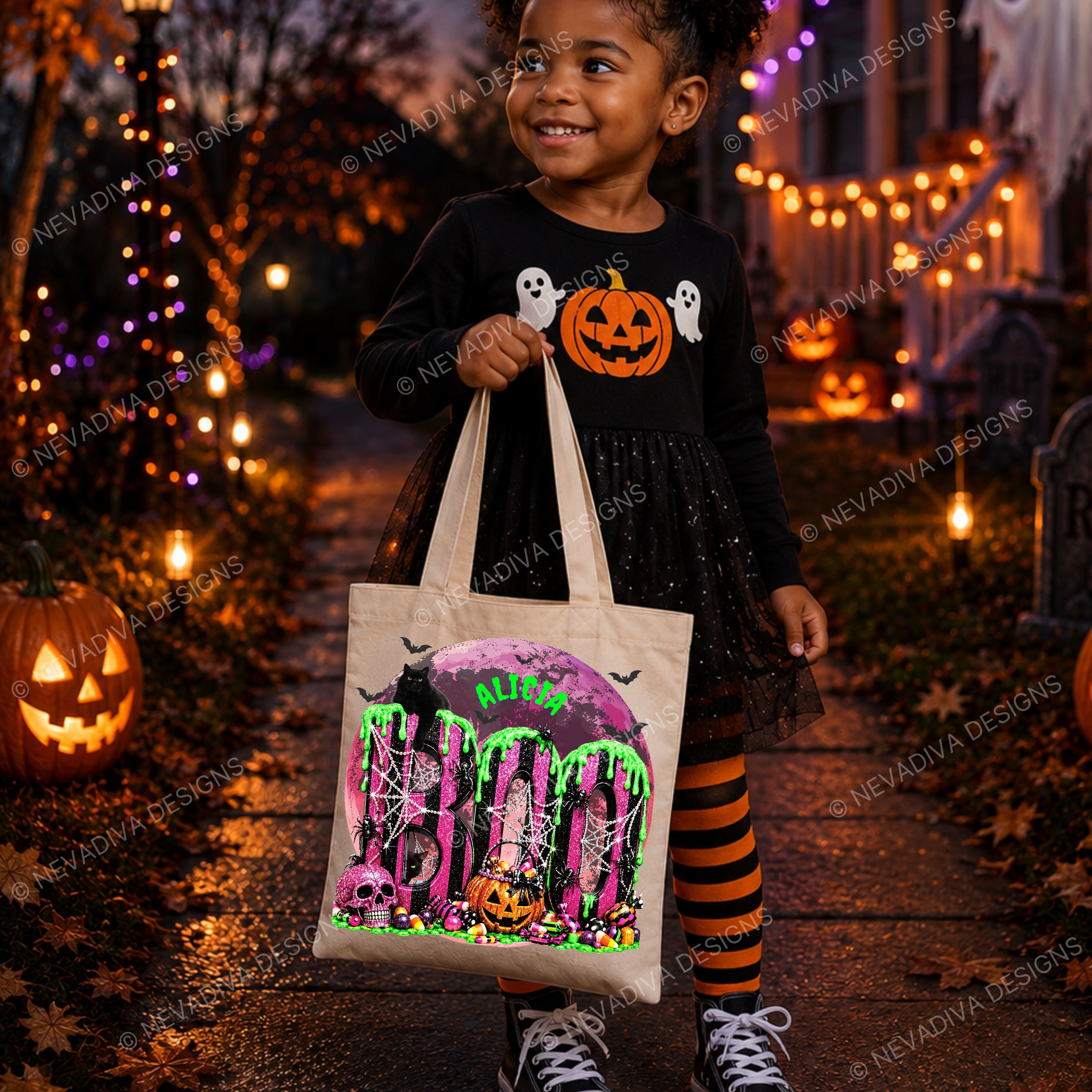 A young girl in a black Halloween dress and orange-and-black striped tights holds a cream canvas tote bag printed with a spooky 'BOO' design, standing on a decorated Halloween porch with pumpkins and string lights.