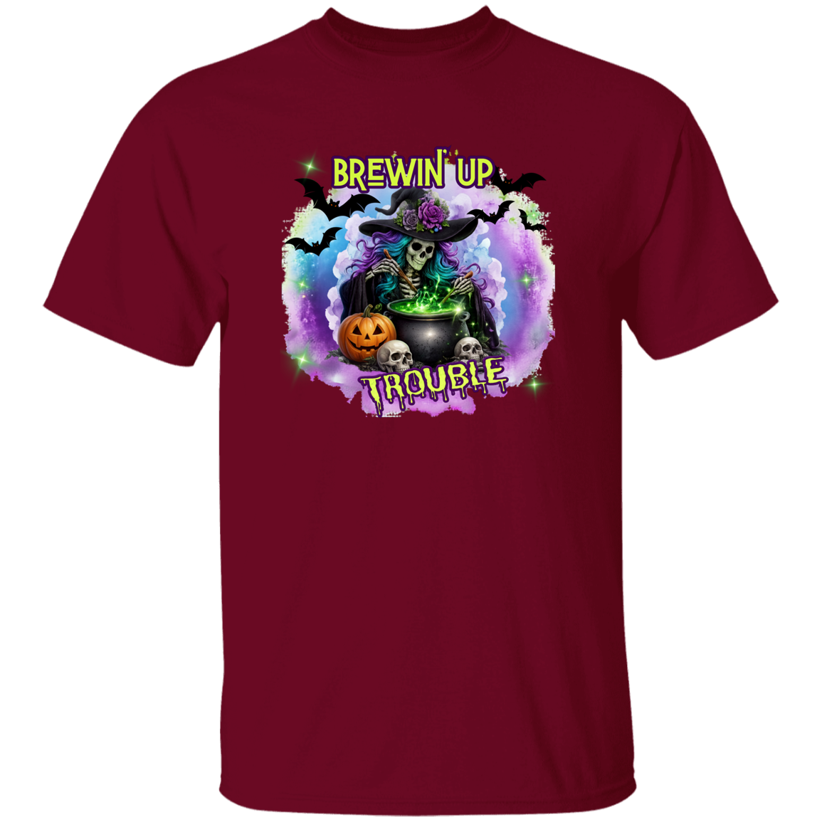 A maroon short-sleeve crewneck t-shirt featuring a colorful Halloween graphic on the chest. The graphic shows a skeleton witch wearing a purple hat and holding a cauldron with green potion, surrounded by a glowing purple and blue aura, a jack-o'-lantern, skulls, bats, and the text 'BREWIN' UP TROUBLE'.