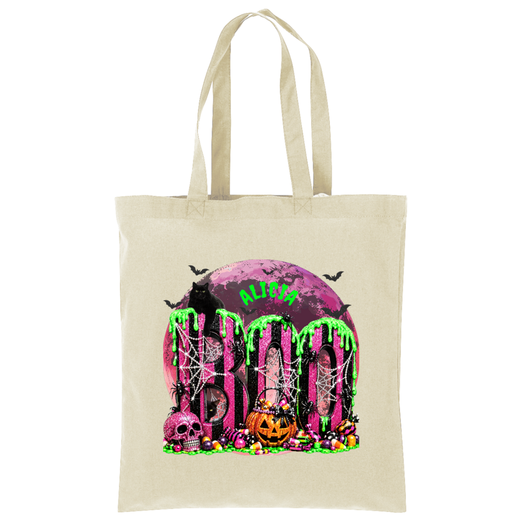 A beige canvas tote bag with a colorful Halloween-themed graphic print featuring the word 'BOO' in dripping neon green over a purple moon, skulls, a jack-o'-lantern, spiders, and bats.