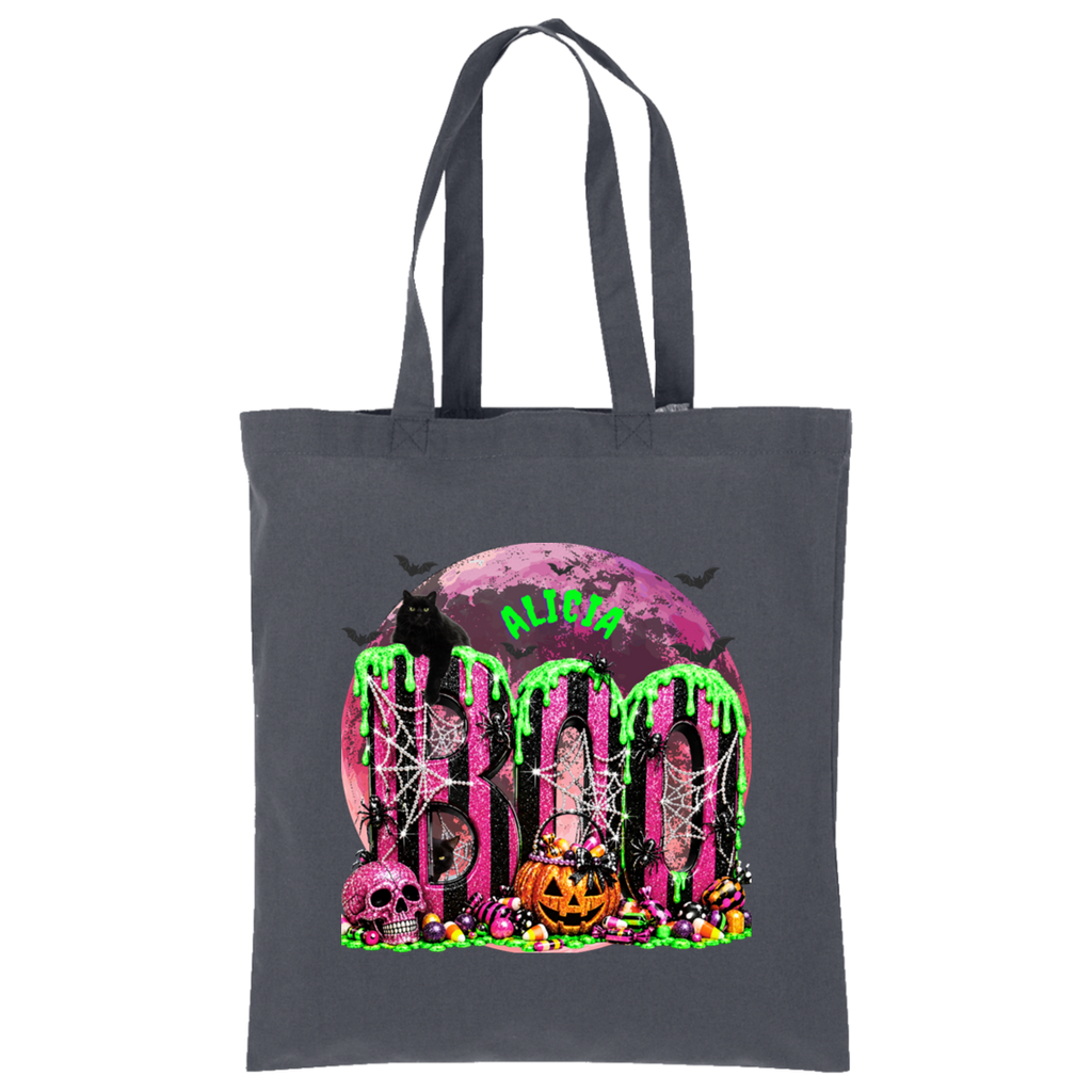 A dark gray canvas tote bag with a vibrant Halloween graphic print featuring the word 'BOO' in dripping neon green letters over a pink moon, spiderwebs, skulls, and pumpkins.
