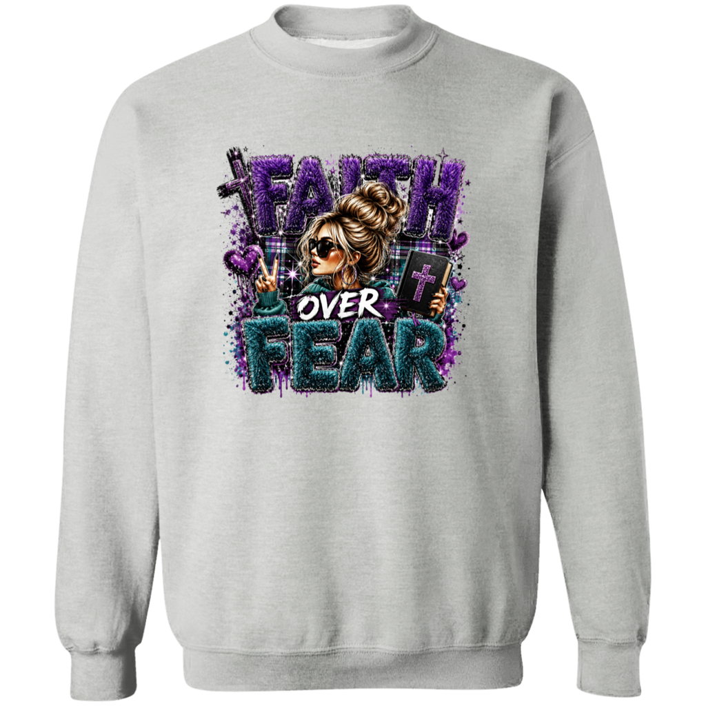 A light gray crewneck sweatshirt featuring a colorful graphic print on the front with the text 'FAITH OVER FEAR' in purple and teal glitter-style lettering, alongside an illustration of a woman in sunglasses.