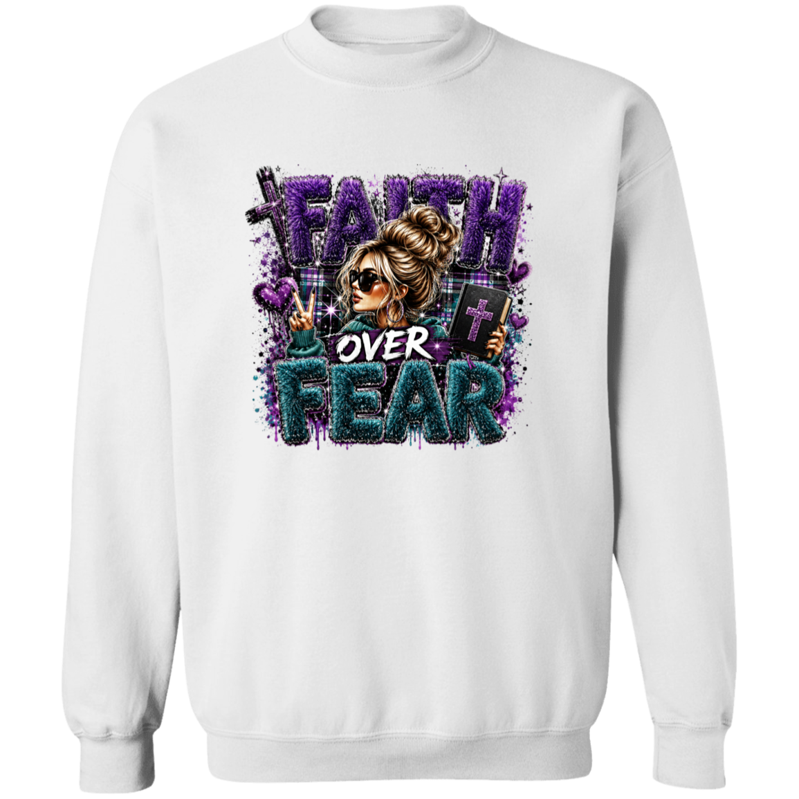 A white crewneck sweatshirt featuring a colorful graphic print on the front with the text 'FAITH OVER FEAR' in purple and teal glitter-style lettering, alongside an illustration of a woman in sunglasses.