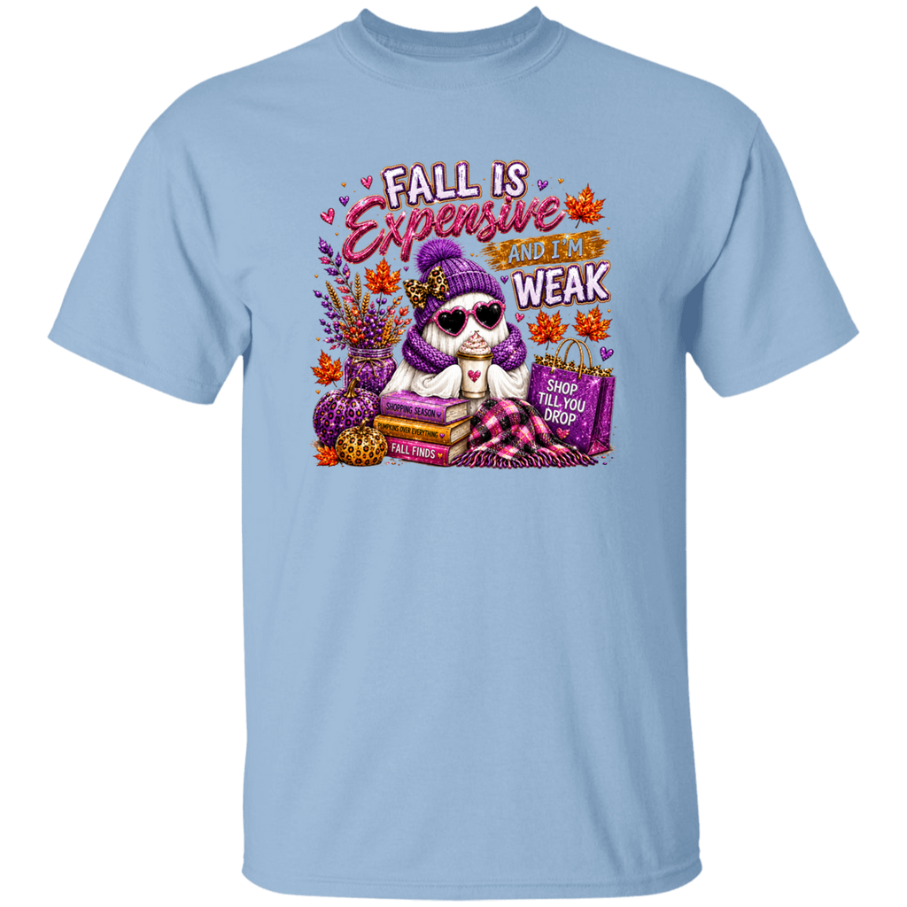 A light blue short-sleeve crewneck t-shirt featuring a colorful graphic print of a ghost wearing a purple beanie and sunglasses, surrounded by fall elements like pumpkins, books, and shopping bags, with the text 'FALL IS Expensive AND I AM WEAK'.