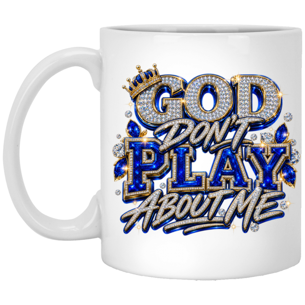 A white ceramic mug featuring a bold graphic design with the text 'GOD DON'T PLAY ABOUT ME' styled in metallic silver, royal blue, and gold with rhinestone-like embellishments.