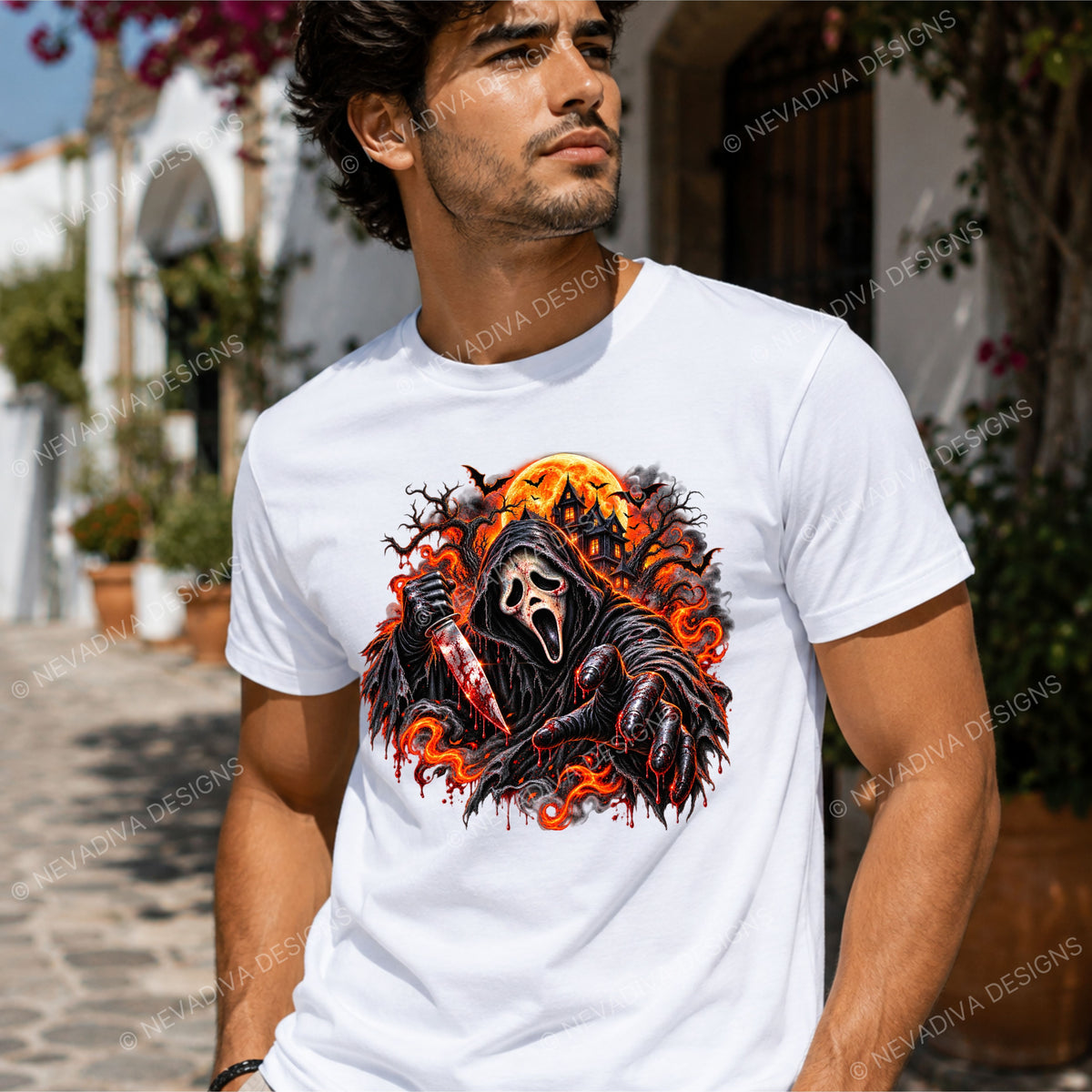 A man wearing a white crew-neck t-shirt with a large graphic print of a horror character in a black hood holding a knife, surrounded by orange flames and a dark background, set against a sunny outdoor street backdrop.