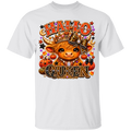 A white short-sleeve crewneck t-shirt featuring a large graphic print on the front. The graphic displays a cute cartoon Scottish Highland cow wearing a leopard-print crown and accessories, surrounded by pumpkins, stars, and the text 'HALLO QUEEN' in a decorative orange and leopard-print font.