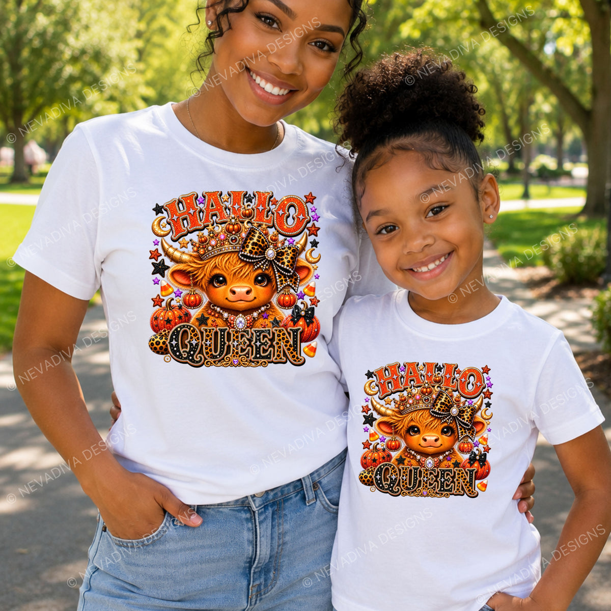 A woman and a young girl wearing matching white graphic t-shirts with a 'HALLO QUEEN' cartoon cow design, standing outdoors in a park setting.