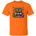 An orange short-sleeve crewneck t-shirt featuring a colorful graphic print of three autumn gnome characters with the text 'Happy Fall Y'all' in teal script, surrounded by fall leaves and pumpkins.