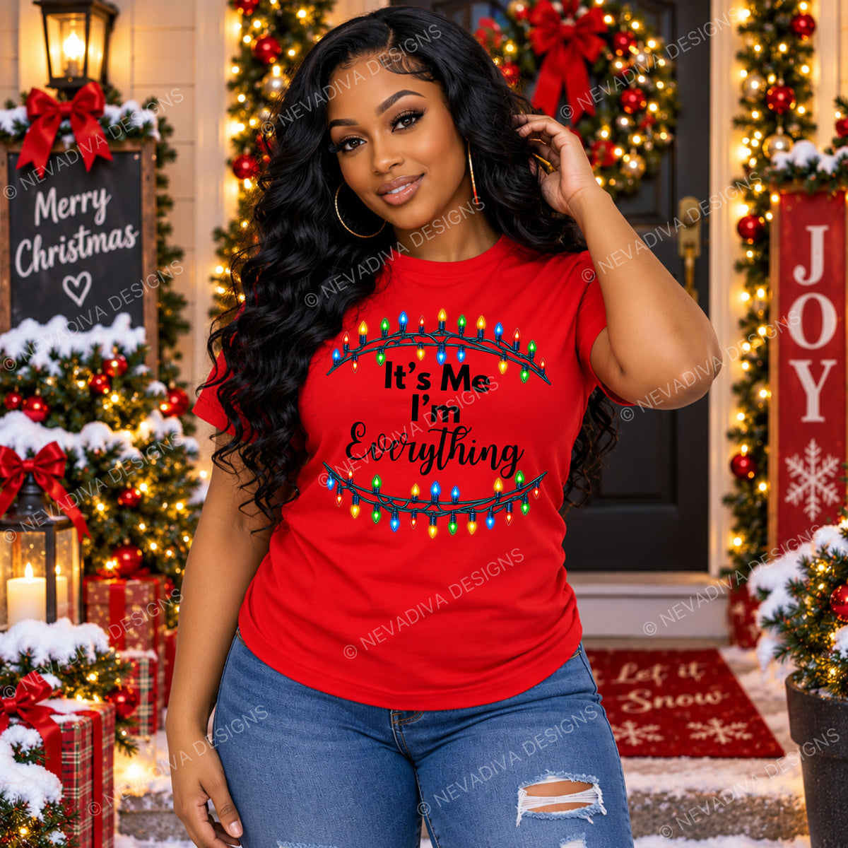 A woman wearing a bright red Christmas graphic t-shirt with the text 'It's Me I'm Everything' under colorful holiday lights, posing in front of a decorated Christmas front door.