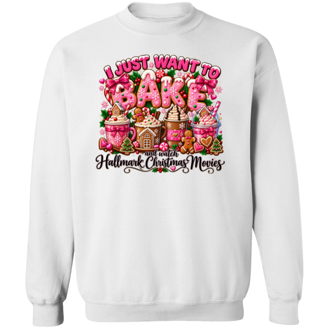 A white crewneck sweatshirt featuring a colorful graphic print on the front. The graphic displays the text 'I JUST WANT TO BAKE' in pink and white bubble letters, above an illustration of gingerbread houses, hot cocoa cups with marshmallows, and gingerbread men, with the phrase 'and watch Hallmark Christmas Movies' written below in black script.