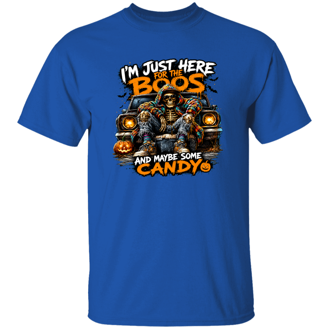 A royal blue short-sleeve crewneck t-shirt featuring a Halloween graphic of a skeleton in a witch hat sitting on a car with jack-o'-lanterns, accompanied by the text 'I'M JUST HERE FOR THE BOOS AND MAYBE SOME CANDY'.