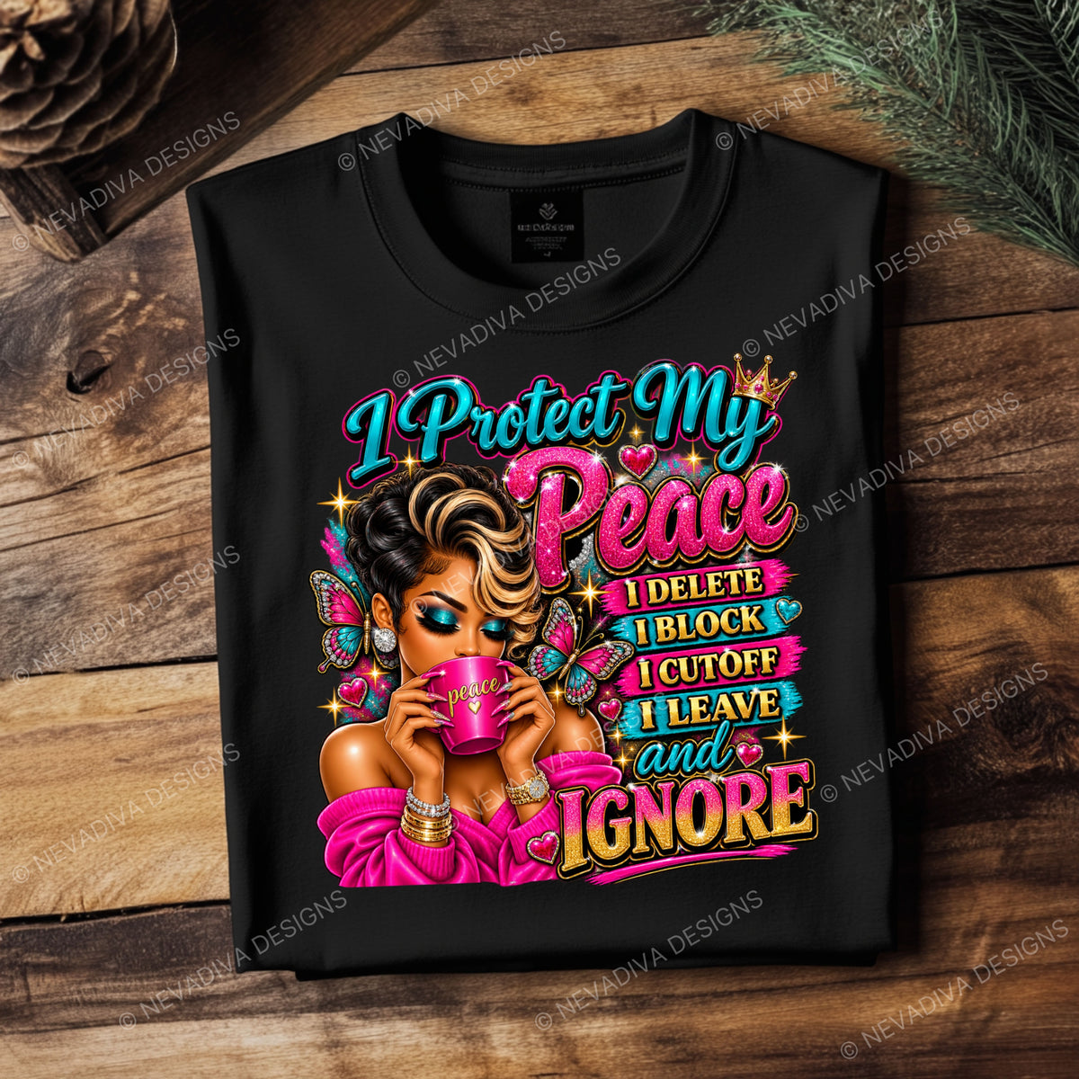 A black short-sleeve graphic T-shirt laid flat on a rustic wooden surface with pine needles and a pinecone. The shirt features a colorful illustrated woman holding a pink mug with bold text reading, 'I Protect My Peace I DELETE I BLOCK I CUTOFF I LEAVE and IGNORE.