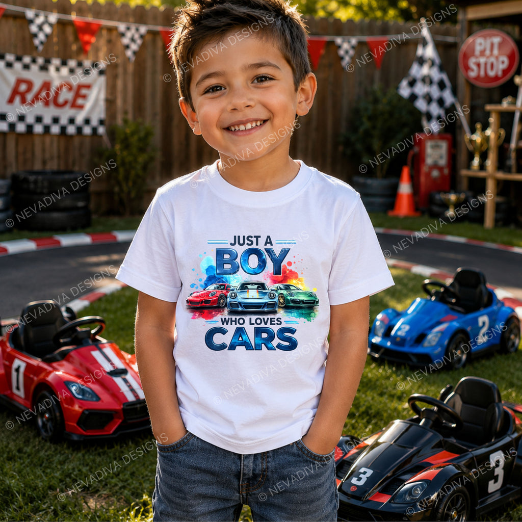 little boy with a white short-sleeve t-shirt with a colorful graphic print on the front. The graphic features the text 'JUST A BOY WHO LOVES CARS' in stylized blue lettering above three sports cars in red, white, and green, set against a clean white background.