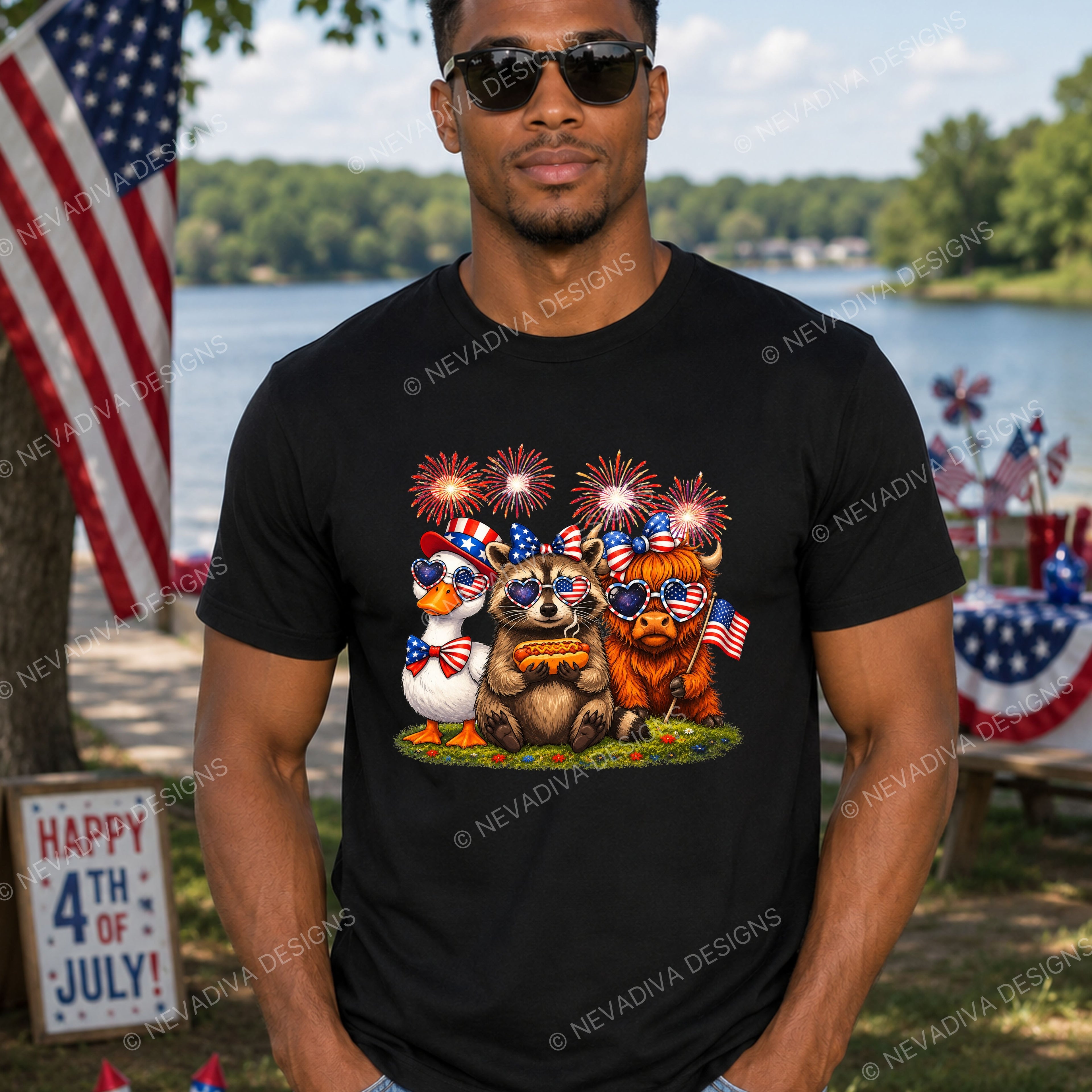 Man wearing a black t-shirt with a 4th of July design featuring animals with American flags and fireworks, standing outdoors near a lake.