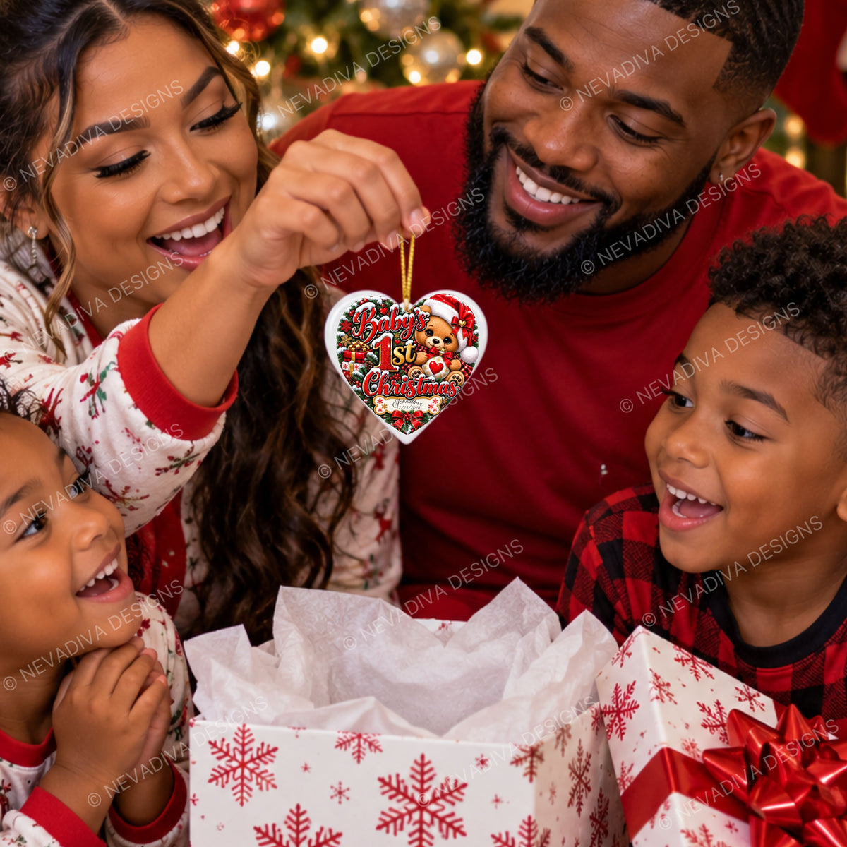A family of four smiling and celebrating around an open gift box with wrapped presents. A woman holds up a heart-shaped Christmas ornament featuring a teddy bear and the words 'Merry Christmas with you, my teddy bear.