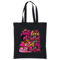 A black canvas tote bag with two black shoulder straps, featuring a colorful graphic print on the front. The graphic displays a Black woman with sunglasses, a crown, butterflies, and skincare items, surrounded by the text 'Self love is the BEST LOVE, and Self care is the BEST CARE' in pink, gold, and white lettering.
