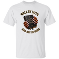 A white short-sleeve crewneck t-shirt featuring a graphic print of hands holding a dark Bible with the words 'FAITH OVER FEAR' and the text 'WALK BY FAITH AND NOT BY SIGHT' in brown and gold.