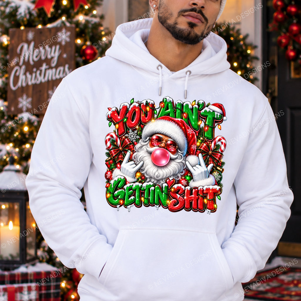 A man wearing a white pullover hoodie with a large, colorful Christmas graphic on the front. The graphic features a cartoon Santa and the text 'YOU AIN'T GETTIN' SHIT' in red and green.