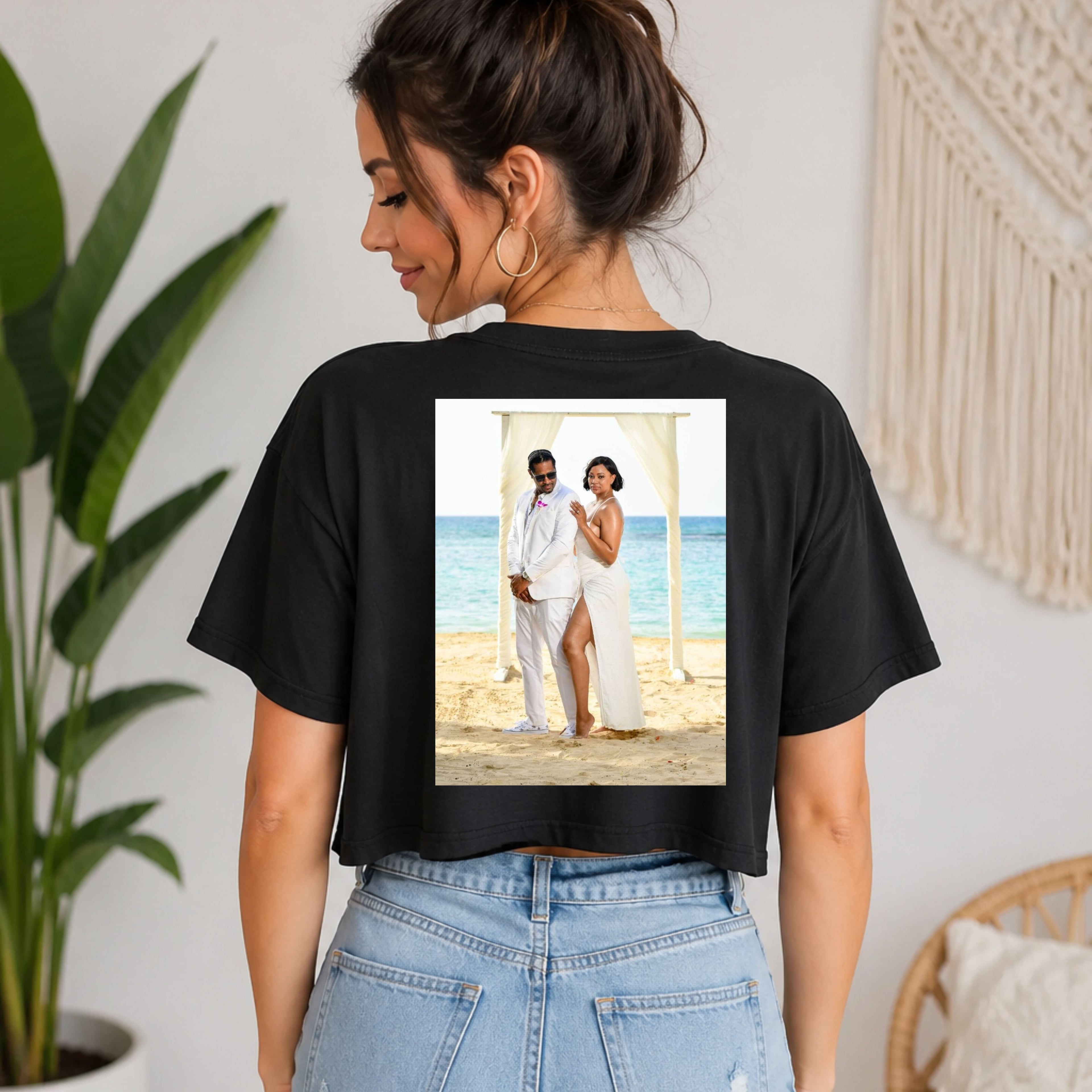 Woman wearing a black t-shirt with a printed image of a couple on a beach.