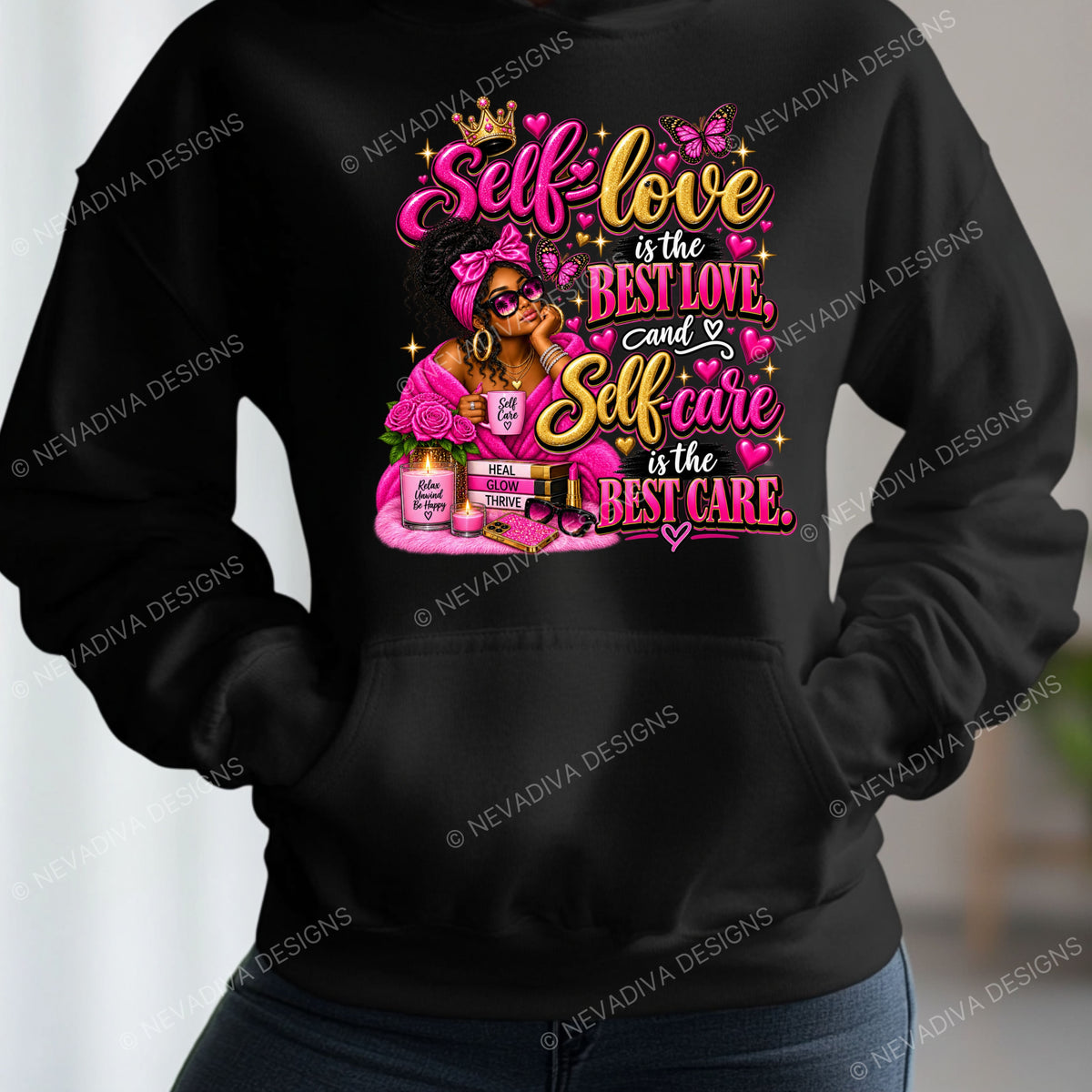 A black hoodie with a colorful graphic print featuring the text 'Self-love is the BEST LOVE, and Self care is the BEST CARE' in pink, yellow, and white lettering, along with a woman in a pink headband and makeup. The hoodie is shown on a model wearing blue jeans, with a blurred indoor background.